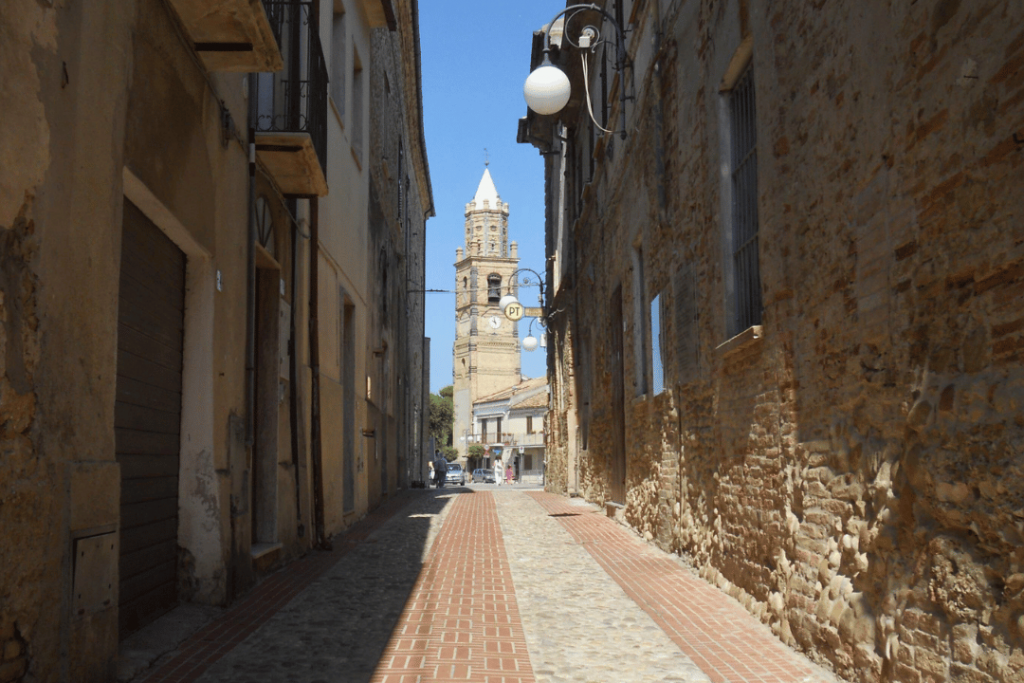 Eine Gasse, an deren Ende ein Kirchturm steht