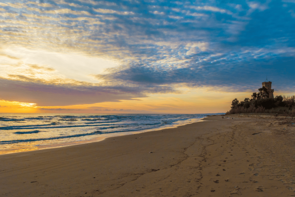 Ein Strand am flachen Meer mit einem Wachturm