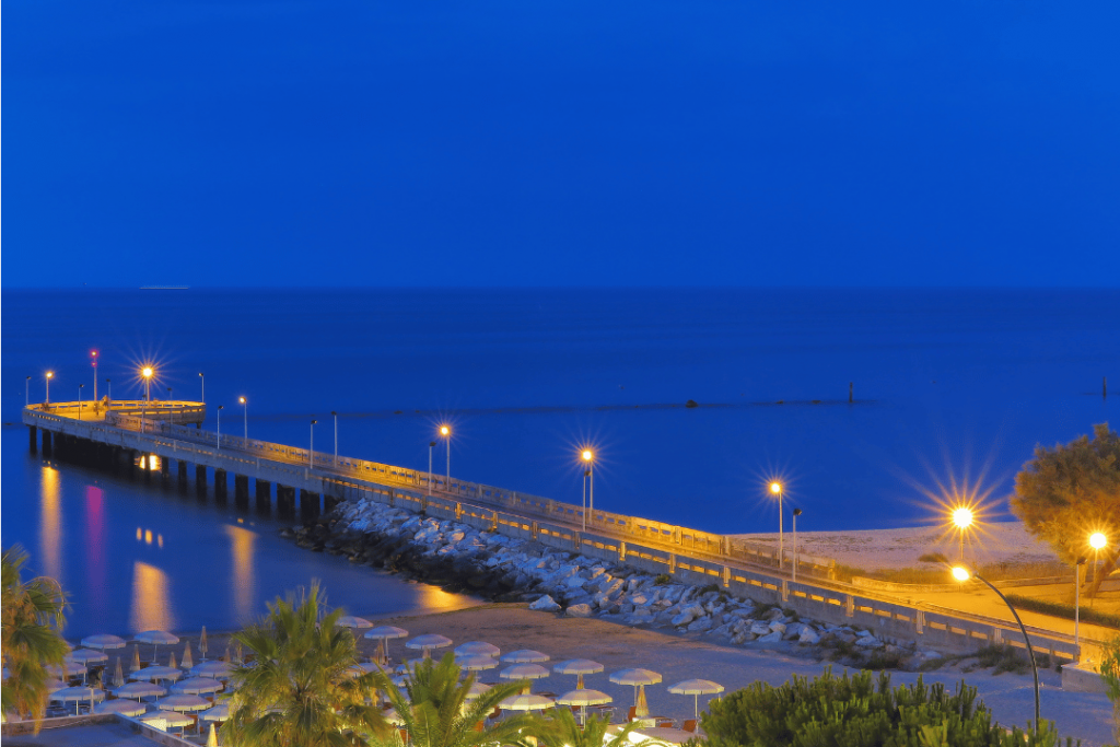 Eine beleuchtete Landungsbrücke im Meer am Abend