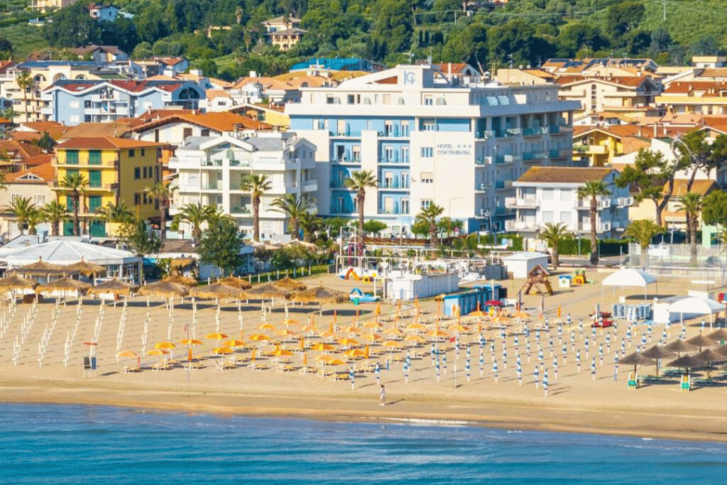 Ein maritimes Hotel an einem Strand mit Sonnenschirmen