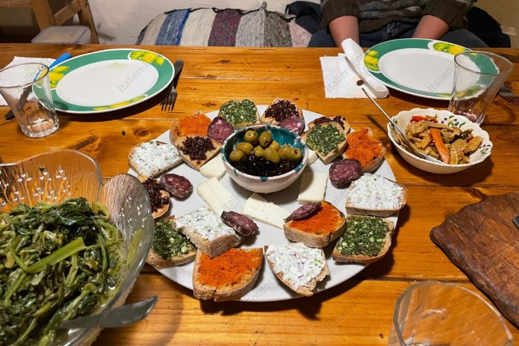 Brot mit Pesto, Aufschnitt und Salate beim Abendessen in Pentedattilo